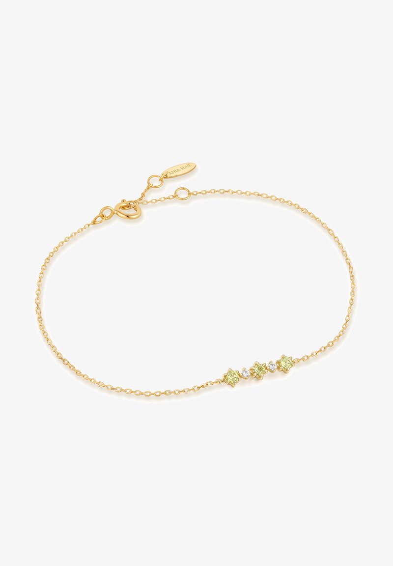 Goldene Kettenarmband mit drei blütenförmigen Akzenten, zwei in hellgrün und einer in klar, betont durch einen Karabinerverschluss.