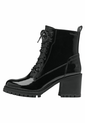 Bottines en cuir verni noir avec un talon épais, dotées d'un laçage à l'avant, d'un bout rond et d'une semelle en caoutchouc texturé avec un motif rugueux.
