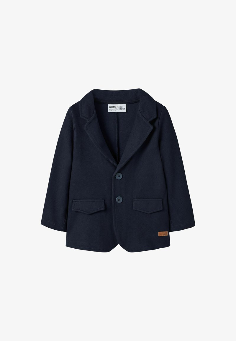 Mørkeblå blazer i børnestørrelse med to fortryk, spidse klaplapper, klaplommer og et lille brunt mærke ved kanten.