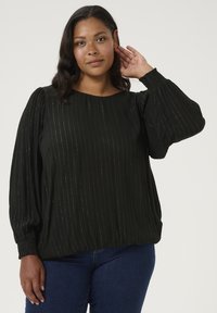 Blouse noire avec de longues manches bouffantes. Rayures scintillantes verticales sur un tissu texturé. Encolure ronde et poignets élastiques, coupe décontractée.