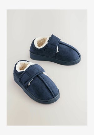 Mornarji modri copati iz mehkega semiša z dlačnatim belim podplatom, zapiranje na ježka in zasnovo okroglega prstnega dela.