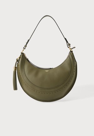Sac à main en cuir vert olive en forme de croissant, avec une seule bandoulière, des éléments dorés et un grand pompon suspendu sur le côté gauche.