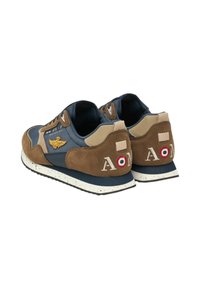 Sneakers da uomo con tomaia in tessuto blu, dettagli in pelle scamosciata marrone, suola bianca con puntini, emblema ricamato e dettagli unici sul tallone.