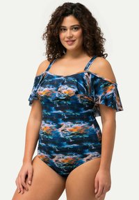 Maillot de bain une pièce multicolore avec des manches à volants dénudées, présentant une base bleue ornée de motifs abstraits orange et rose.
