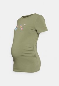 Camiseta de maternidad verde con mangas cortas, con bordado floral en rosa, azul y blanco. Detalle de fruncido lateral para una forma ajustada.