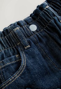 Mørkeblå denim shorts med elastisk talje, sølvknap og kontrasterende gul syning. Har to frontlommer.