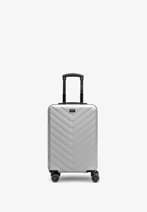 Silberner Hartschalenkoffer mit teleskopischem Griff und vier schwarzen Spinner-Rädern auf einem weißen Hintergrund.