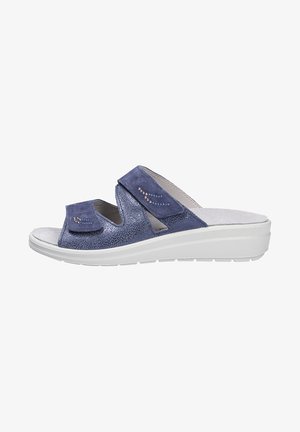 Blue suede slip-on sandals with two adjustable straps, textured upper, and white cushioned sole. Features subtle decorative stitching.