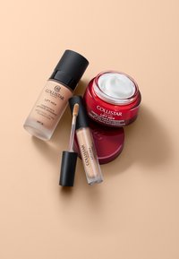 Bouteille de fond de teint lissant liftant Collistar Lift HD+, anti-cernes avec applicateur, et pot de crème raffermissante sur fond beige.
