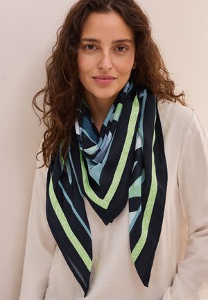 Sciarpa triangolare multicolore in navy, verde e blu con motivi geometrici e una texture leggera e morbida, drappeggiata attorno al collo.