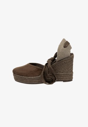 Wedge espadrille de ante marrón con suela de yute trenzado, tacón de tela beige texturizada y cintas de tela alrededor del tobillo para un ajuste seguro.