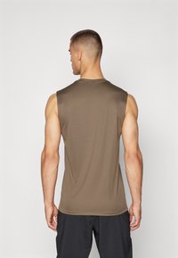 Camiseta atlética sin mangas en tejido verde olivo oscuro. Textura suave, diseño ajustado y dobladillo curvado. Escote liso, con un detalle mínimo.