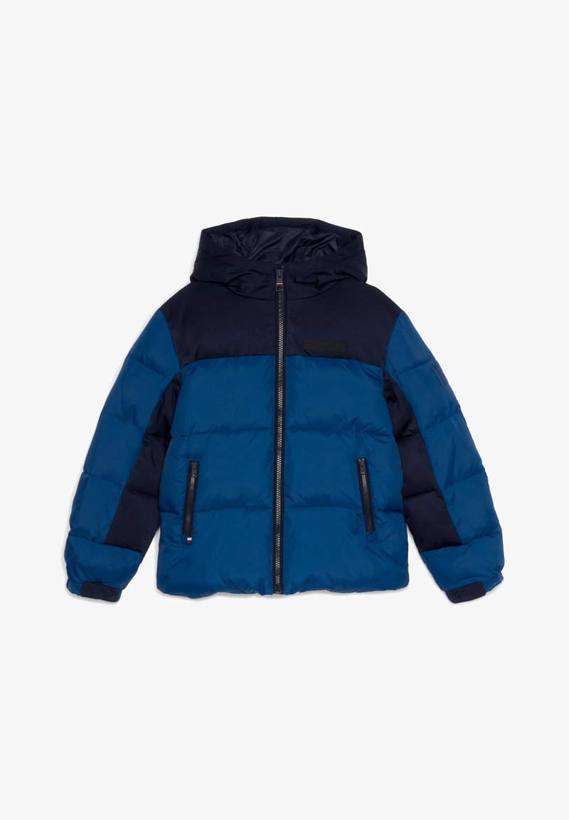 Veste d'hiver matelassée bleu et marine avec capuche, fermeture éclair à l'avant, poches zippées et poignets réglables à Velcro.