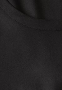 Schwarzer Stoff mit glatter Textur, runder Ausschnitt und feiner Naht, der ein minimalistisches Design hervorhebt.