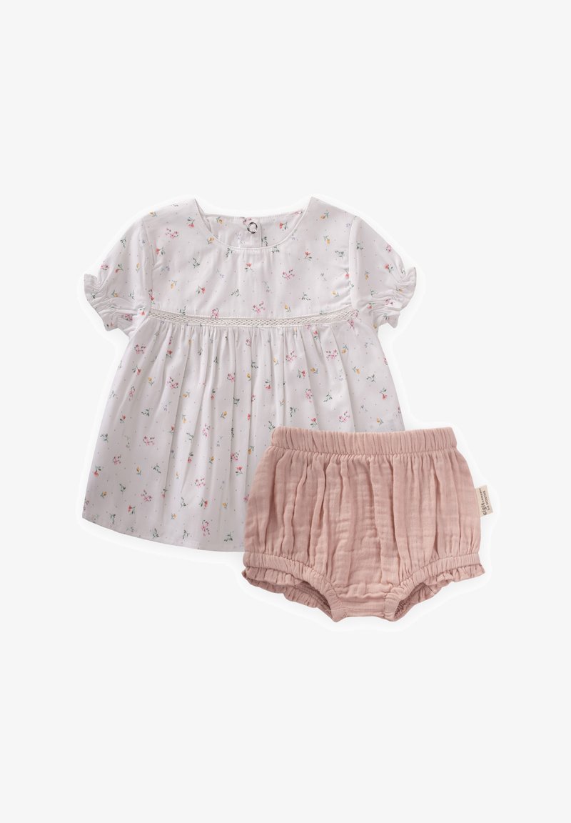 Bela bombažna majica s cvetnim vzorcem, kratkimi nabranimi rokavi in gumbom. Ujemajoče se roza nabrane bombažne kratke hlače z elastičnim pasom.