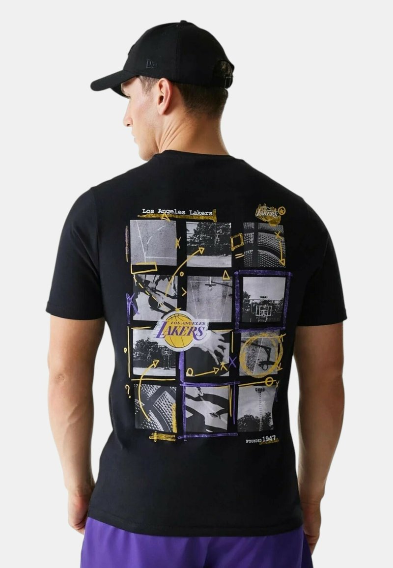 Uomo che indossa un cappellino nero e una maglietta nera con pantaloni corti viola; la parte posteriore della maglietta presenta una grafica del logo dei Los Angeles Lakers.