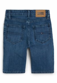 Tummansiniset farkkushortsit, joissa on kaksi takataskua, pieni Tommy Hilfiger -logo oikeassa taskussa ja ruskea merkkilogo vyötäröllä.