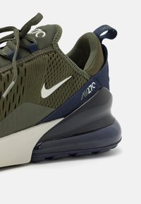 Nike Air Max 270, s tamnim maslinastim mrežastim gornjim dijelom, mornarskim plavim naglascima, bijelim swoosh logotipom i velikom jastučićem za udobnost u crnoj boji.