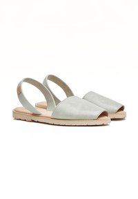 Sandalias de ante gris tipo slingback con punta abierta, forma redondeada, plantilla acolchada y suela de goma en color beige claro.