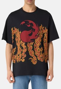 Sorte bomulds T-shirt med store rød-og-gul flammegrafikker, oversized pasform, rund hals og korte ærmer.