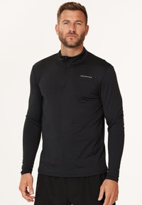 Sort langærmet atletisk top med halv-zip krave, der har et tætsiddende design og let, glat stof. Inkluderer "Endurance" logo på brystet.