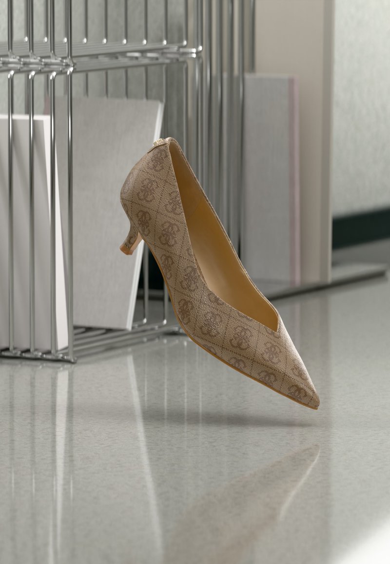 Chaussure beige à talon kitten pointu avec un motif subtil, flottant au-dessus d'une surface réfléchissante près d'organisateurs en fil métallique.