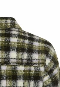 Zielona i biała koszula flanelowa w kratę o miękkiej teksturze, z klasycznym kołnierzykiem i widocznym szwem na ramieniu.