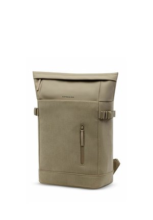 Sac à dos beige à fermeture roulante, façade en tissu côtelé, petite poche verticale zippée, sangles latérales à boucle et logo "Kapten & Son" sur la partie supérieure.