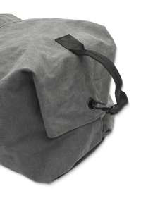 Grau Canvas-Duffle-Bag mit strukturierter Oberfläche, ausgestattet mit einem schwarzen Riemen und einem Metallclip zum Verschluss sowie einer gefalteten Oberkante.