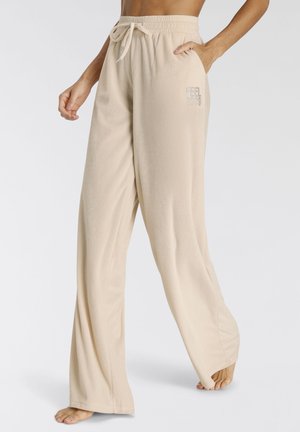 Beigeweite Sweatpants aus weichem Stoff, mit einem elastischen Bund und Kordelzug sowie einem kleinen "FEEL GOOD"-Textdesign an der Hüfte.