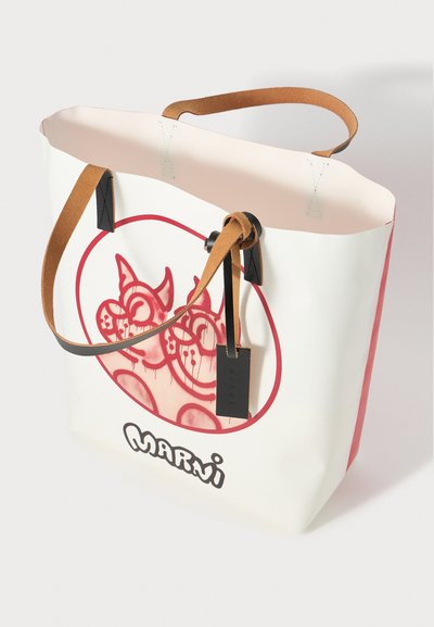 White tote bag with pink interior, brown leather handles, black accents, and a circular red graphic featuring playful character designs.