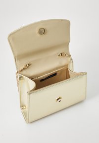 Gold metallic clutch bag with a snap closure. Interior features a smooth fabric lining and a chain strap for versatile carrying options.