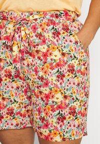 Květinové šortky z lehké látky s vícero barevným vzorem obsahujícím červené, růžové a žluté květy, se stahovací pasem a kapsami.