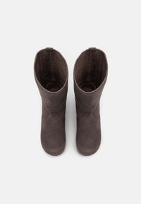 Brązowe zamszowe botki za kostkę o gładkiej fakturze, zaokrąglonym czubku i detalach szwu bocznego, z wysokim, prostym otwarciem cholewki.