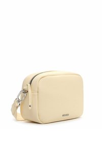 Bolso bandolera rectangular compacto de color crema con cierre de cremallera y correa ajustable con cierre metálico.