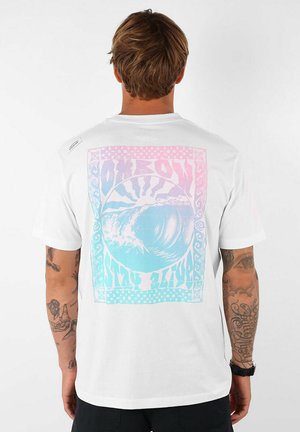 T-shirt en coton blanc avec un design graphique coloré d'une vague aux teintes pastel, entourée de motifs décoratifs et de texte.