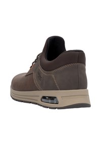 Zapatilla de cuero marrón con un acabado texturizado, forma redondeada, cuello acolchado y una suela intermedia beige que presenta un detalle de amortiguación visible.