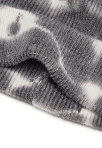 Tejido de punto gris y blanco con un patrón y una textura acanalada, que presenta fibras suaves y ligeras variaciones de color. El borde está doblado.