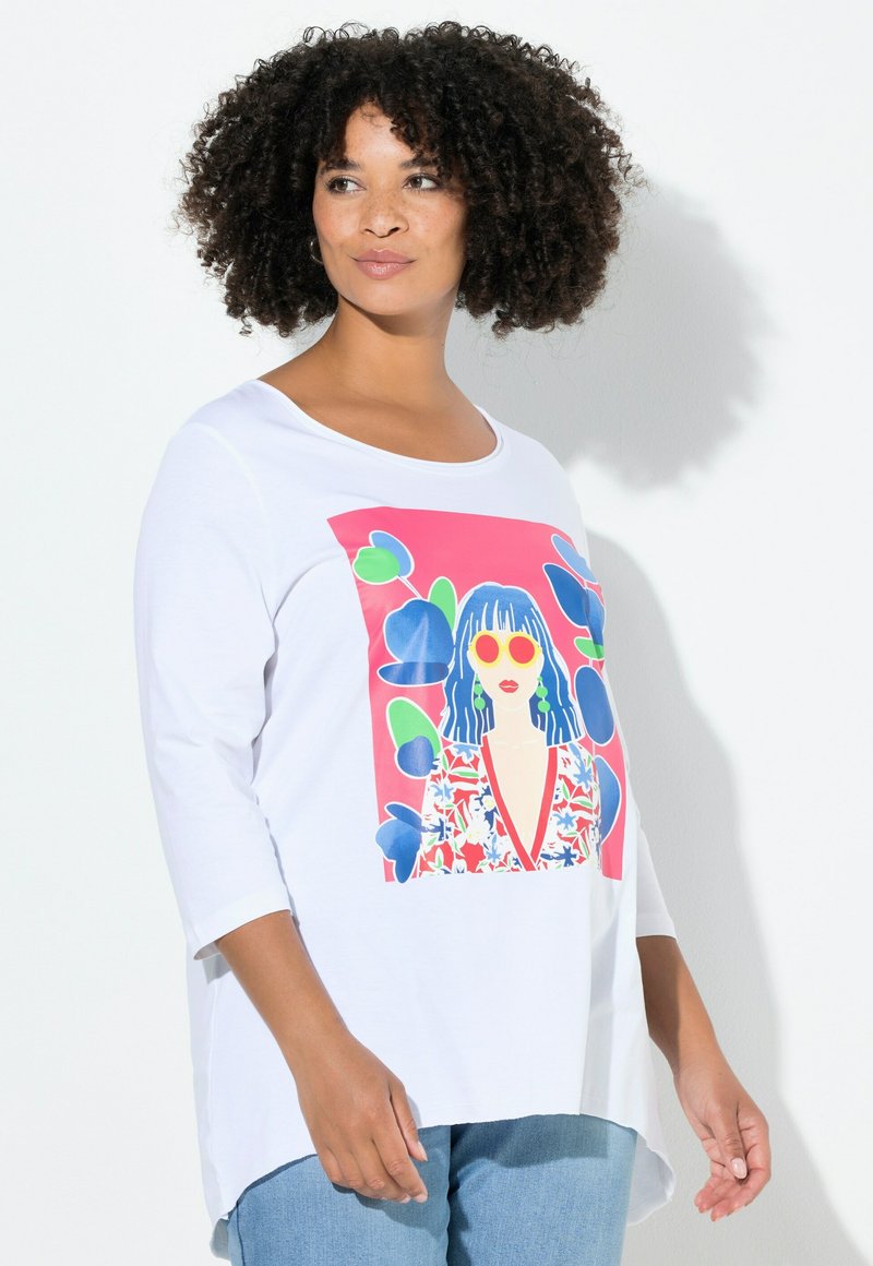 Witte lange mouwen T-shirt met een levendige grafische print van een gestileerde vrouw met blauw haar en kleurrijke bloemaccenten.