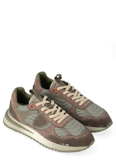Un paio di sneaker marroni e verde oliva con pannelli in rete e suede, lacci beige e suole in crema strutturate, angolate leggermente a destra.