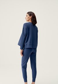 Marineblå sweatshirt med en avslappet passform og ribbede mansjetter, kombinert med matchende tapered joggebukser med elastisk midje.
