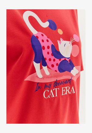 Czerwona koszulka z grafiką rozciągającego się kota w niebieskim i różowym kolorze w kropki, z napisem "W mojej erze kota w dół."