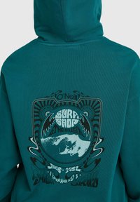 Turquoise capuchonsweatshirt met een grafische print van golven en tekst. Gemaakt van katoen, met geribbelde manchetten en een capuchon met trekkoord.