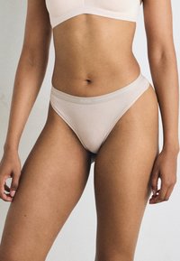 Culotte en thong beige clair avec un tissu doux et lisse et une taille élastique fine arborant un discret logo "BOSS".