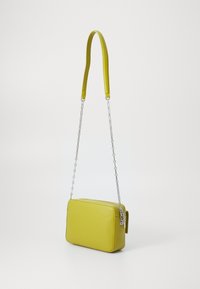 Borsa a tracolla rettangolare in pelle gialla brillante. Caratterizzata da una tracolla a catena e una superficie liscia, con chiusura a zip e dettagli laterali a linguetta.