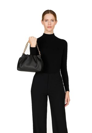 Borsa a tracolla in pelle nera con design arricciato, tracolla in catena dorata e texture morbida. Tenuta da una persona con un top e pantaloni neri.