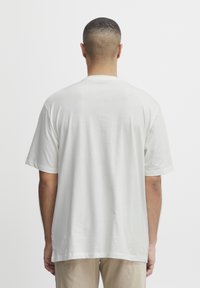White, short-sleeved t-shirt made of soft cotton, featuring a crew neck and a relaxed fit. Smooth texture with no visible patterns or accents.
