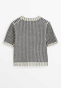 Pull court en maille noir et blanc avec motif zigzag vertical et col, poignets et ourlet côtelés.