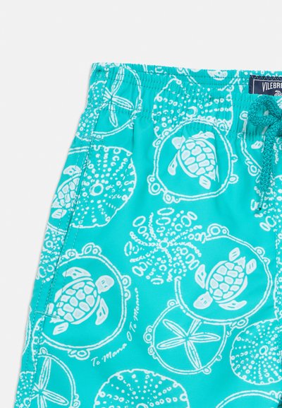 Türkise Badeshorts mit weißen Mustern von Schildkröten und Meeresmotiven. Mit elastischem Bund, Kordelzug und gesteppten Details.