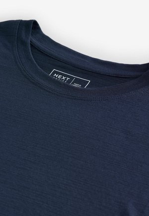 Navy blue short-sleeve t-shirt made of smooth fabric with a crew neck. Features a label with "NEXT ACTIVE" text at the neckline.